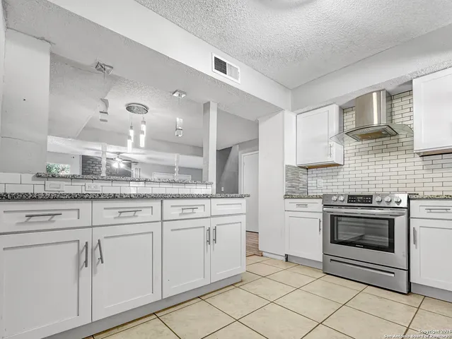 a bathroom with a granite countertop sink a toilet and shower