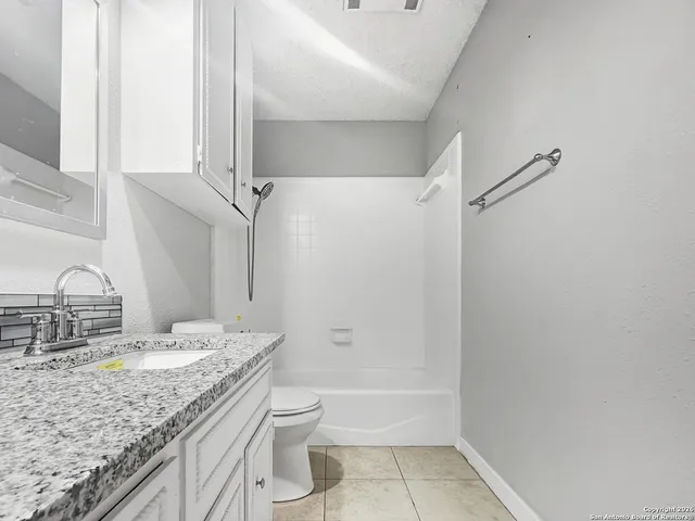a view of a room with a ceiling fan and wooden floor