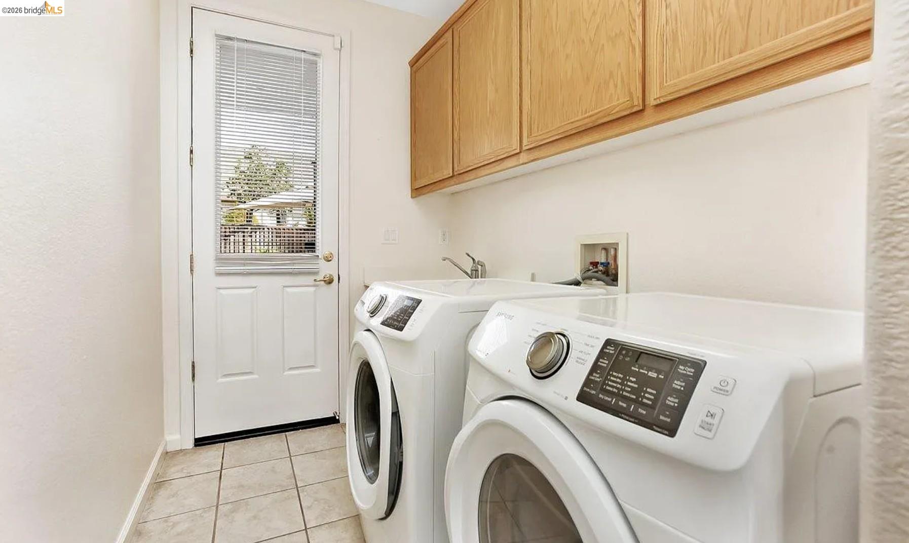 3251 Lookout Point Loop Discovery Bay, CA 94505 - Photo 13 of 31 Laundry room featuring cabinet space, washer and clothes dryer, and light tile patterned floors