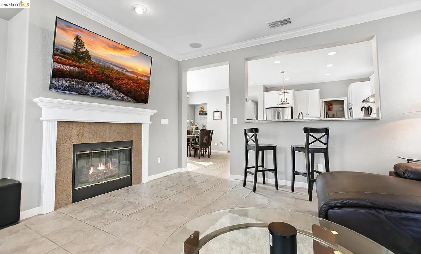 3251 Lookout Point Loop Discovery Bay, CA 94505 - Photo 7 of 31 Living area with recessed lighting, light tile patterned flooring, crown molding, and a glass covered fireplace