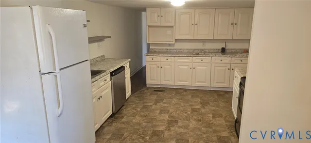 a kitchen with white cabinets and refrigerator