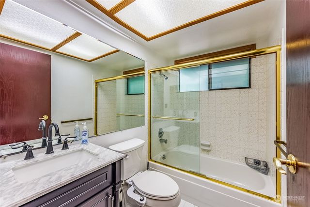 a bathroom with a granite countertop sink toilet a mirror and shower