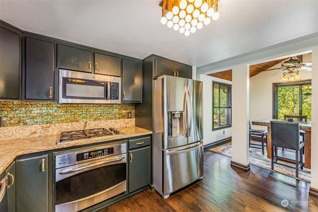 a kitchen with stainless steel appliances granite countertop a refrigerator stove and sink