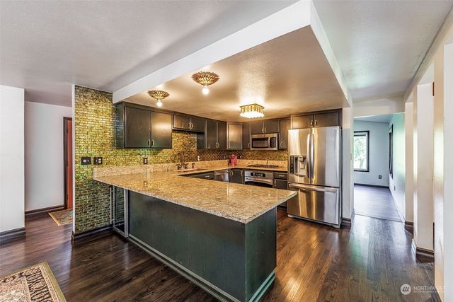 a large kitchen with a center island and stainless steel appliances