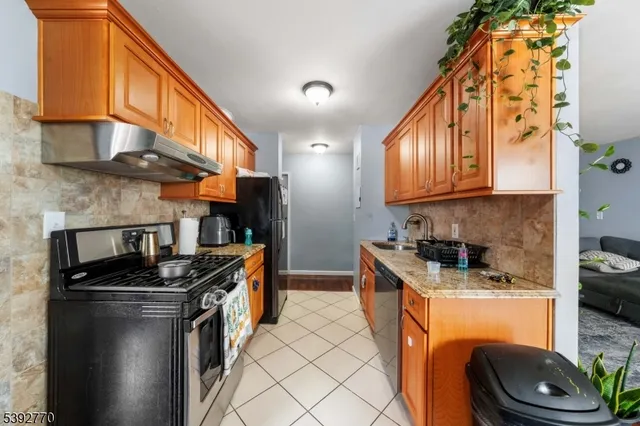 a kitchen with stainless steel appliances granite countertop a sink a stove and a refrigerator