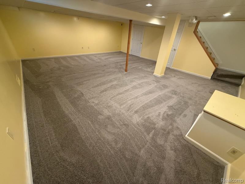 28144 Yorktown Road Farmington, MI 48331 - Photo 21 of 25 Spacious lower-level room featuring light yellow walls and gray carpet flooring