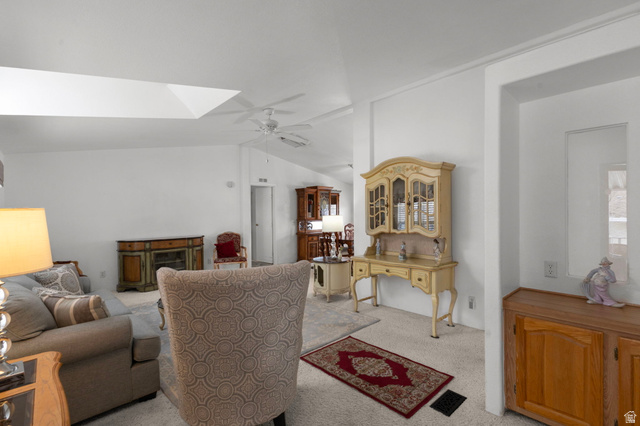 2600 North Hill Field Road, Unit 134 Layton, UT 84041 - Photo 6 of 41 Living area featuring lofted ceiling, a ceiling fan, light colored carpet, and a fireplace