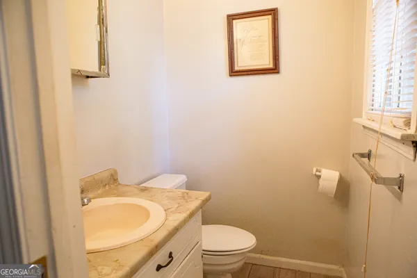 a bathroom with a granite countertop toilet and a sink