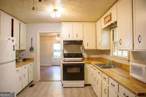 a kitchen with granite countertop a stove top oven sink and refrigerator