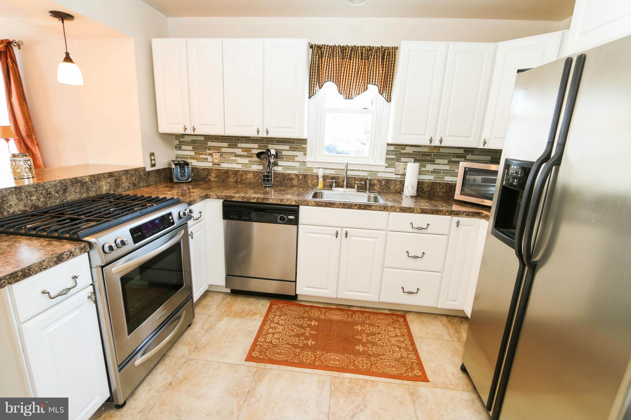 4228 East Joppa Road Baltimore, MD 21236 - Photo 11 of 28 a kitchen with stainless steel appliances a stove a sink and a refrigerator