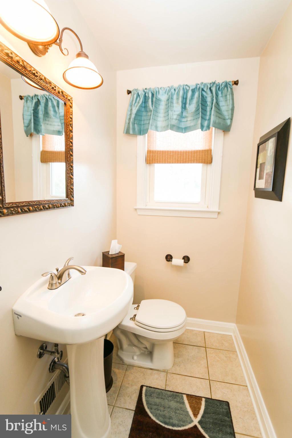 4228 East Joppa Road Baltimore, MD 21236 - Photo 15 of 28 a bathroom with a sink a toilet and a mirror