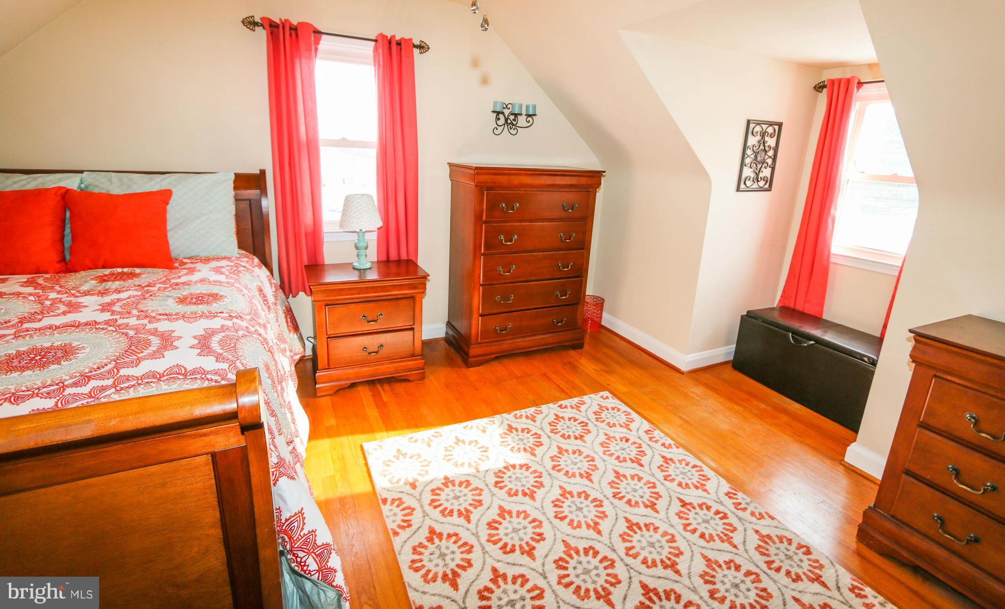 4228 East Joppa Road Baltimore, MD 21236 - Photo 22 of 28 a bedroom with a bed and a flat tv screen on dresser