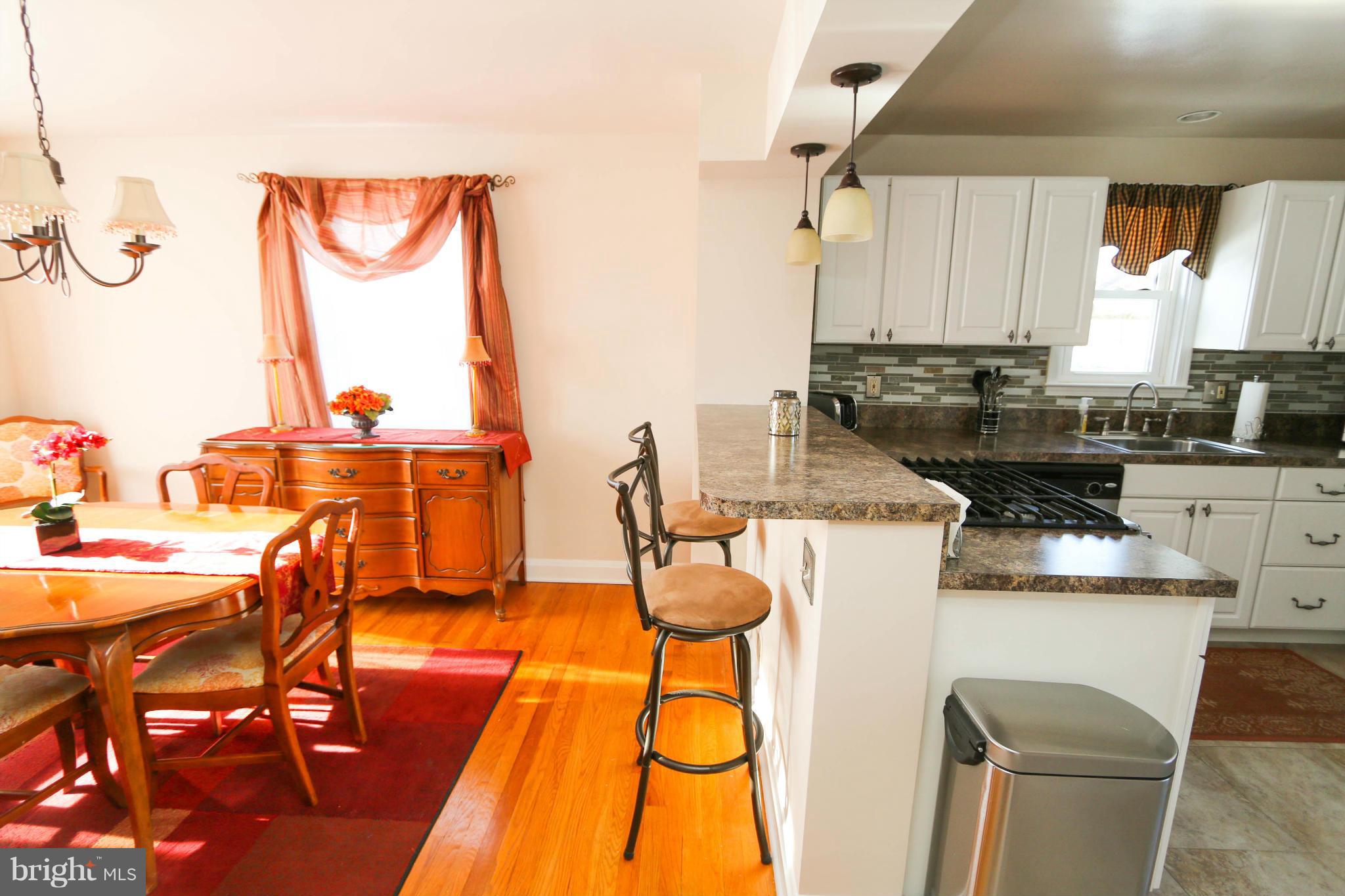 4228 East Joppa Road Baltimore, MD 21236 - Photo 7 of 28 a kitchen with a table chairs and a wooden floor