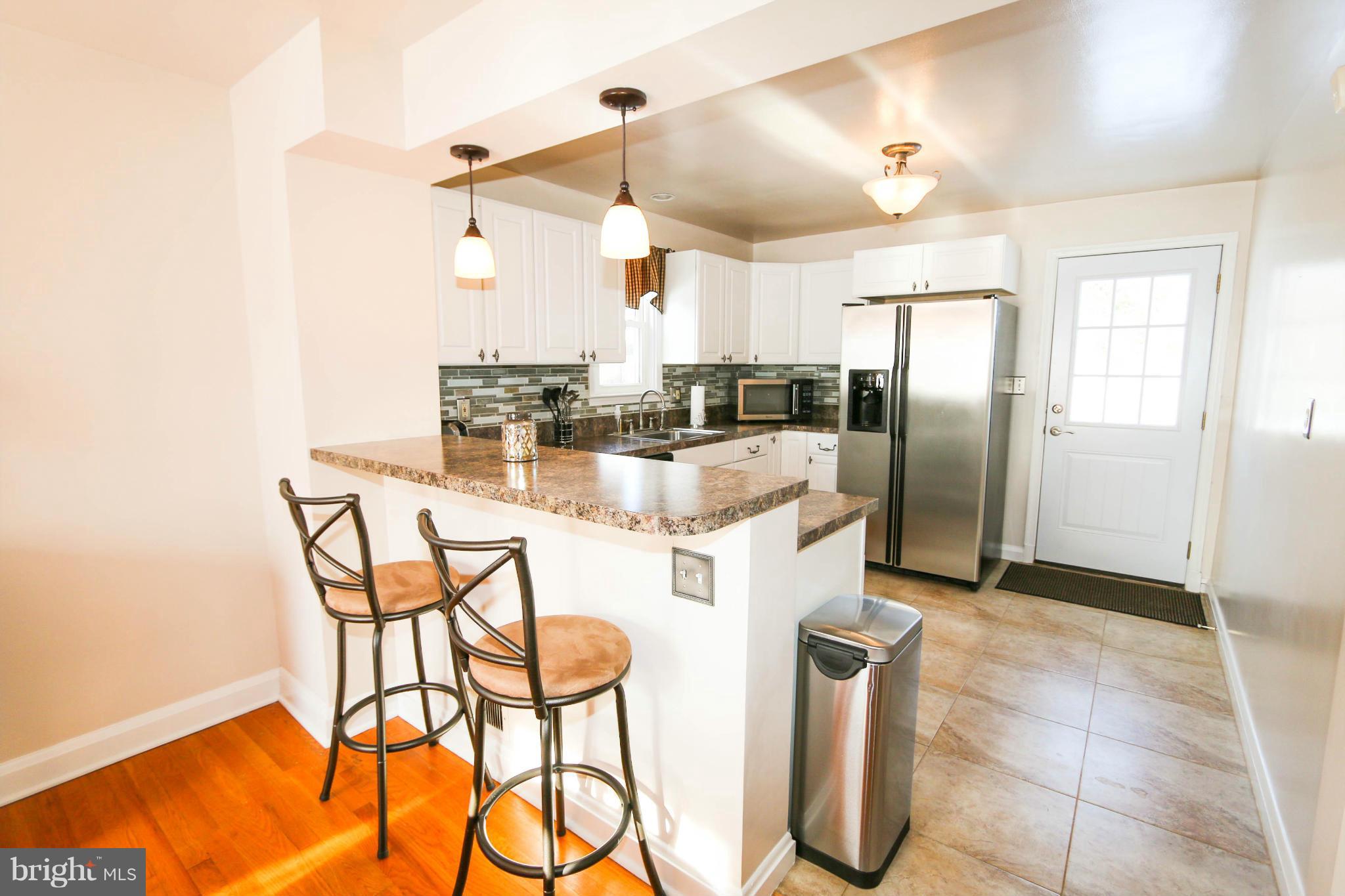 4228 East Joppa Road Baltimore, MD 21236 - Photo 8 of 28 a kitchen with stainless steel appliances kitchen island granite countertop a table and chairs