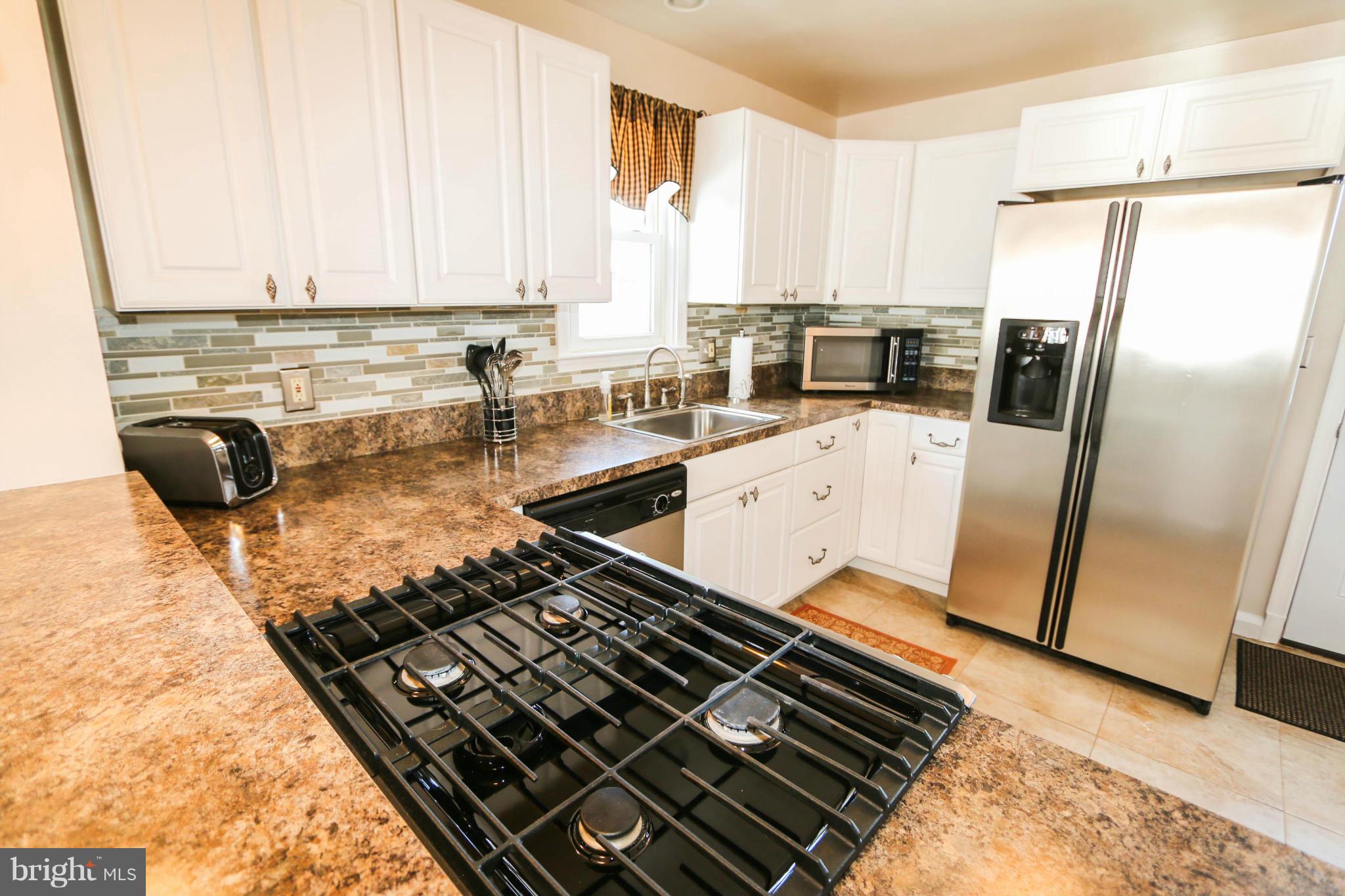 4228 East Joppa Road Baltimore, MD 21236 - Photo 9 of 28 a kitchen with wooden cabinets and a stove top oven