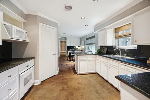 a kitchen with granite countertop a sink stove and refrigerator