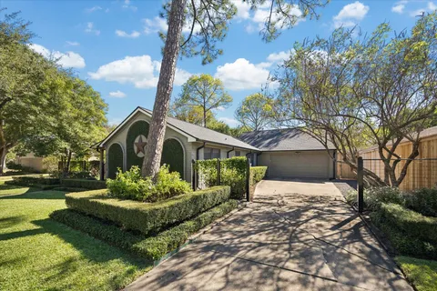 a front view of a house with a garden and trees