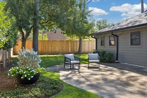 a view of a chair and table in backyard of the house