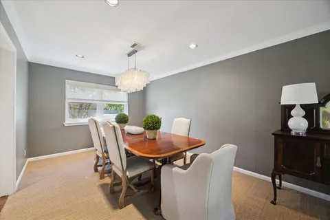 a dining room with furniture a chandelier and window