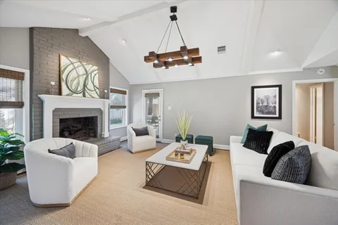 a living room with furniture a fireplace and a chandelier