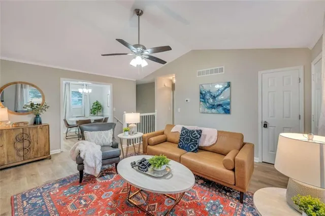 a living room with furniture a dining table and a chandelier