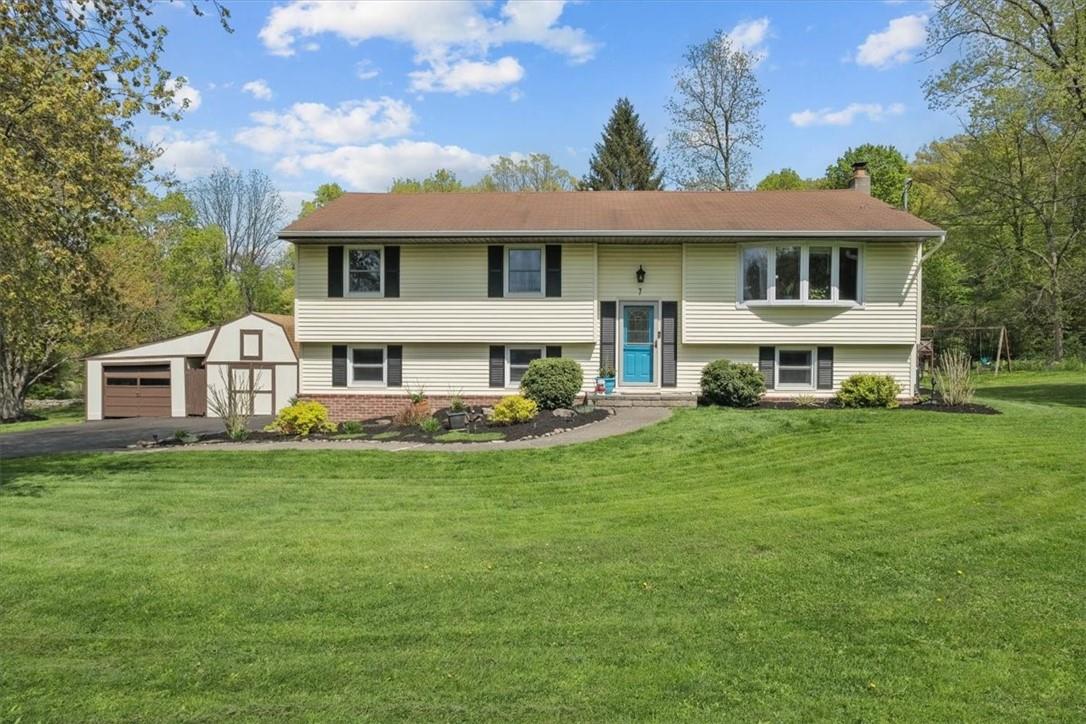 a view of a yard in front of a house with a large tree
