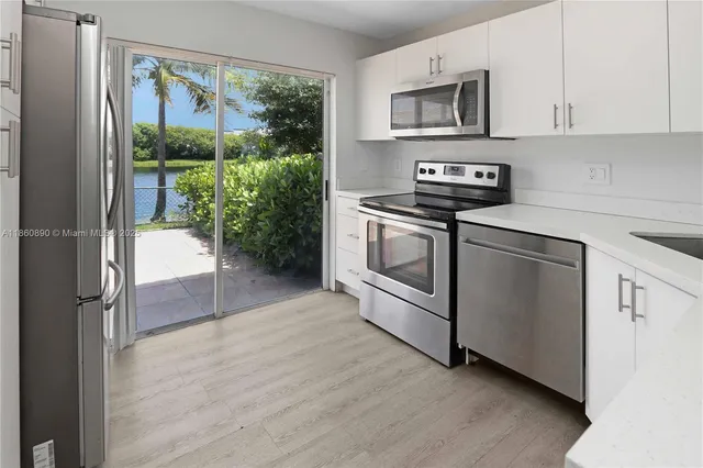 a kitchen with stainless steel appliances granite countertop a refrigerator and a stove