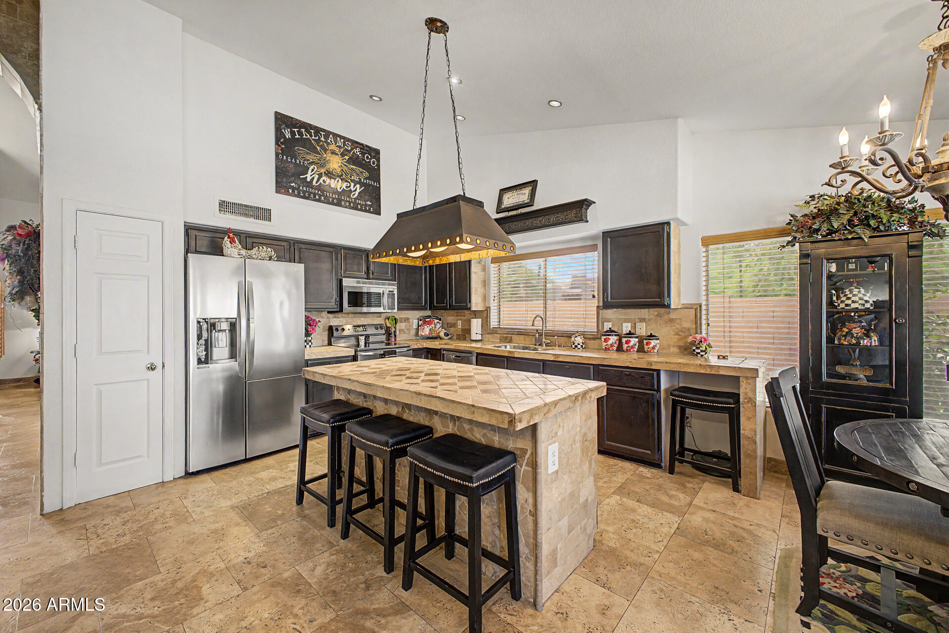 3948 North Ranier Mesa, AZ 85215 - Photo 18 of 69 a kitchen with stainless steel appliances granite countertop a stove top oven a sink a dining table and chairs
