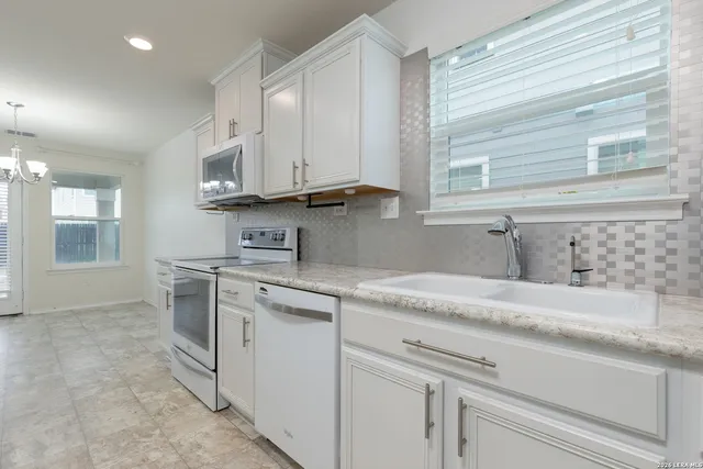 a kitchen with stainless steel appliances granite countertop a sink and a stove