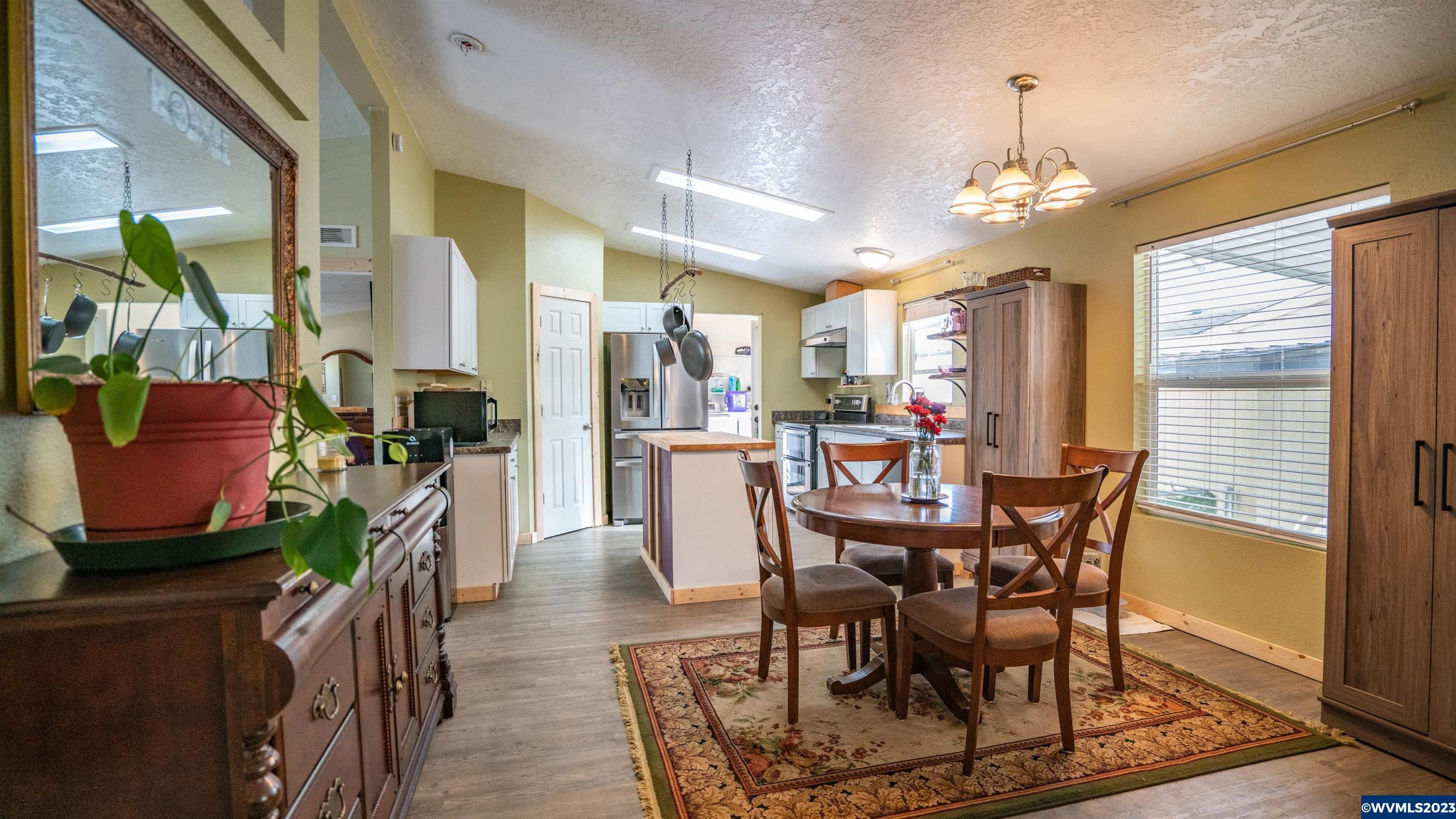 950 Hoffman Road Northeast, Unit 61 Salem, OR 97301 - Photo 7 of 40 a view of a dining room with furniture a chandelier and wooden floor