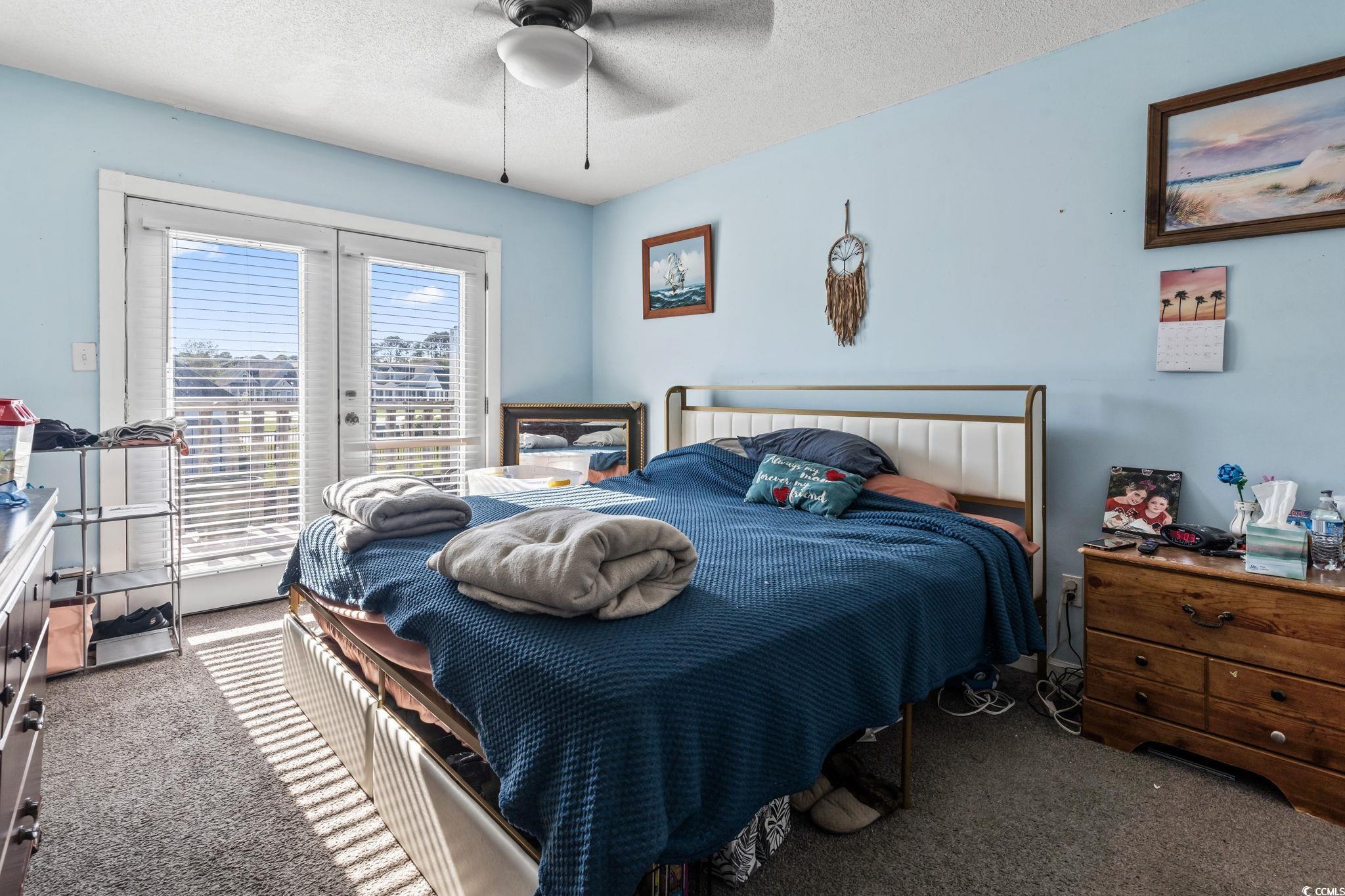 1411 Turkey Ridge Road, Unit 30B Surfside Beach, SC 29575 - Photo 13 of 21 Bedroom with french doors, a textured ceiling, carpet, a ceiling fan, and access to outside
