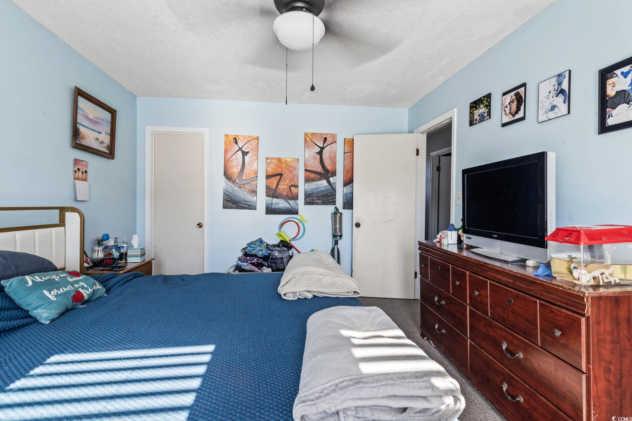 1411 Turkey Ridge Road, Unit 30B Surfside Beach, SC 29575 - Photo 14 of 21 Carpeted bedroom with a ceiling fan and a textured ceiling