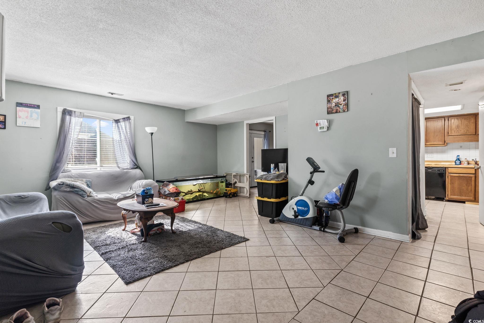 1411 Turkey Ridge Road, Unit 30B Surfside Beach, SC 29575 - Photo 2 of 21 Living area with a textured ceiling and light tile patterned flooring