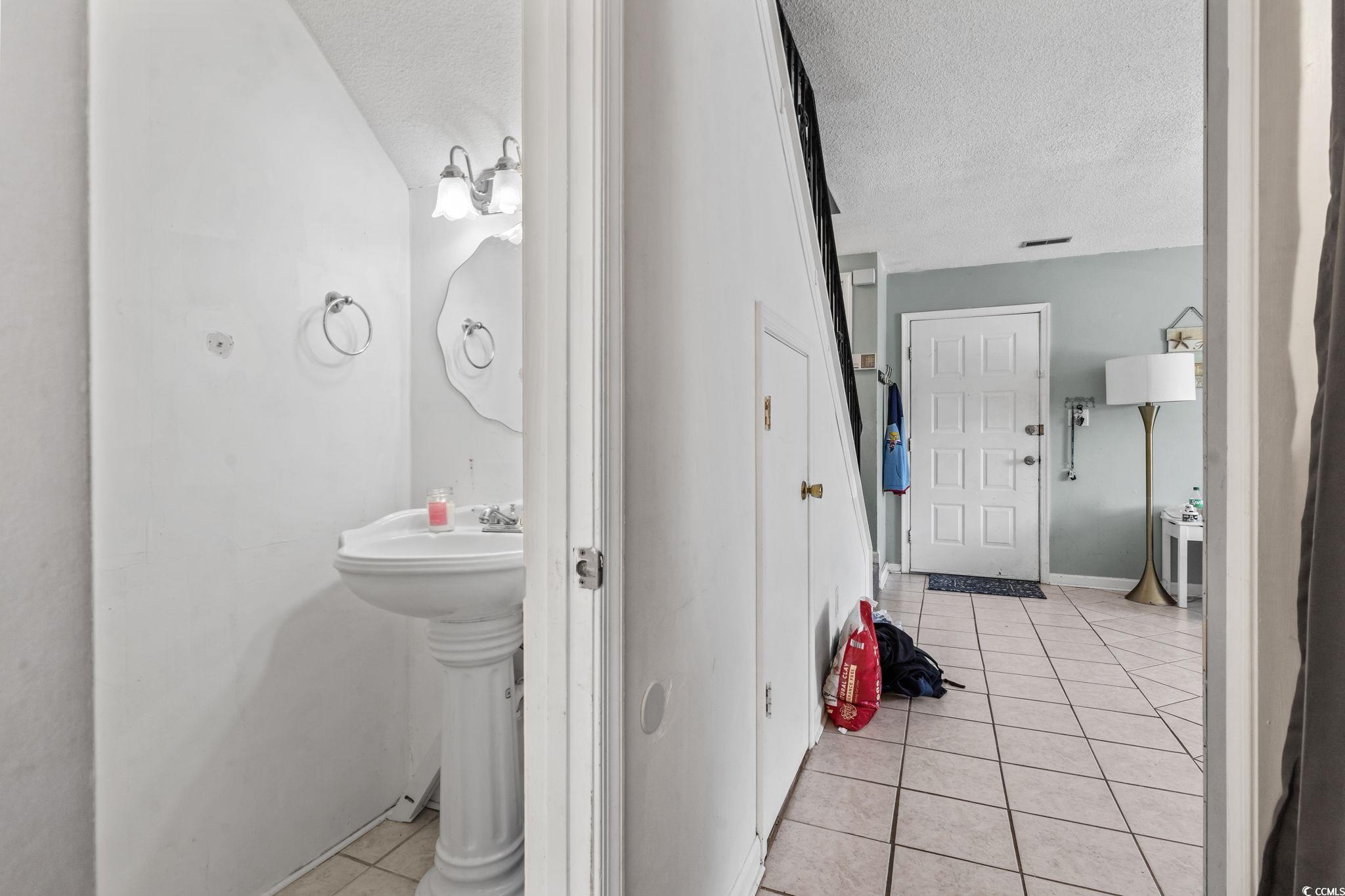 1411 Turkey Ridge Road, Unit 30B Surfside Beach, SC 29575 - Photo 9 of 21 Bathroom with a textured ceiling, tile patterned floors, and baseboards