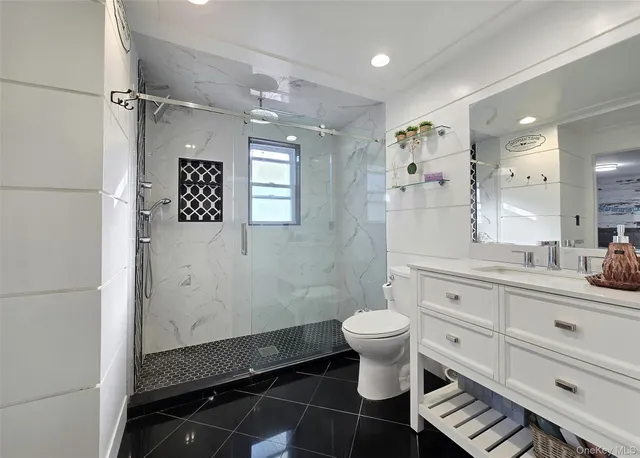 a bathroom with a sink toilet a mirror and shower