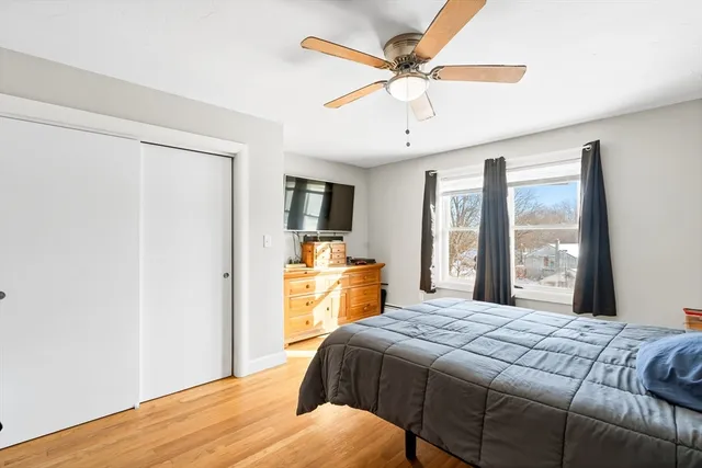 a bedroom with a large bed a chandelier and dresser