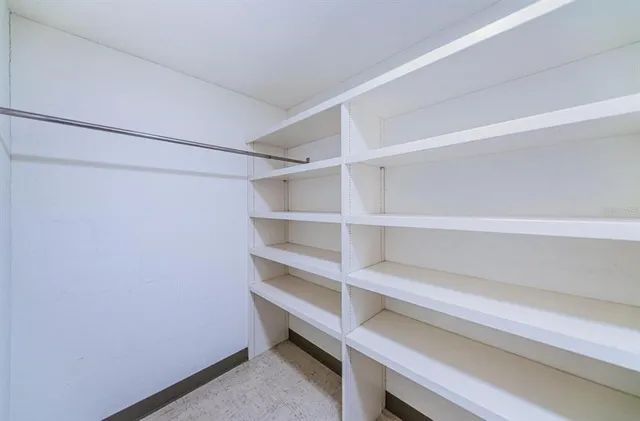 a view of walk in closet with empty racks