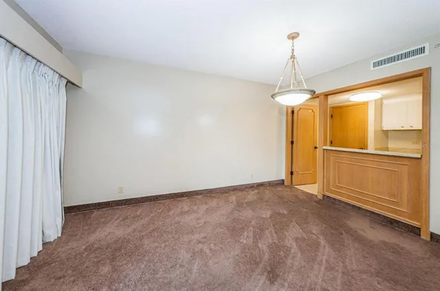 a view of empty room with cabinet and chandelier