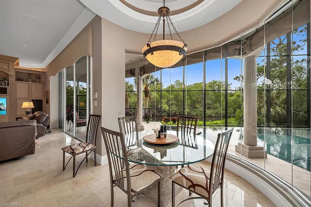 1237 Pocantico Lane Naples, FL 34110 - Photo 3 of 20 a view of a dining room with furniture wooden floor and chandelier