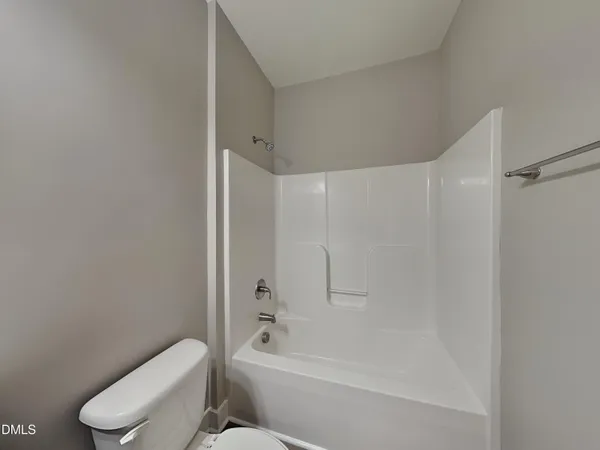 a white toilet sitting next to a bath tub