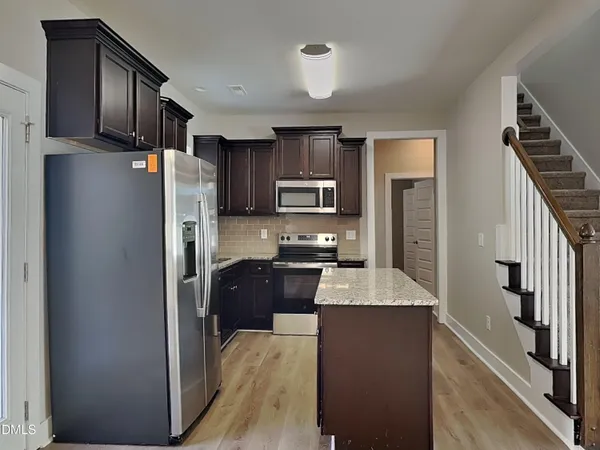 a kitchen with stainless steel appliances granite countertop a refrigerator stove and oven
