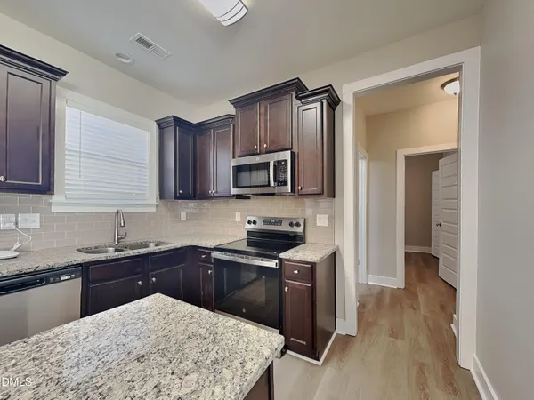 a kitchen with a sink stove and refrigerator