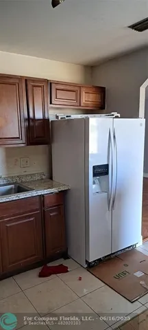 a kitchen with stainless steel appliances granite countertop a refrigerator and a sink