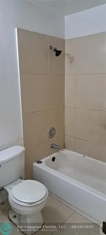 a white toilet sitting next to a bath tub and a shower