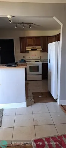 a kitchen with stainless steel appliances granite countertop a refrigerator and a stove