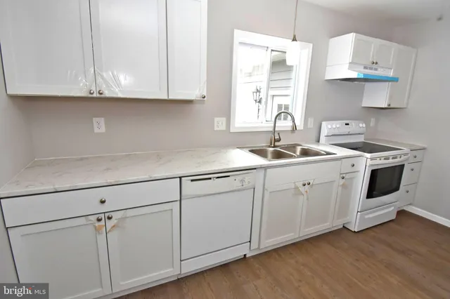 a kitchen with stainless steel appliances granite countertop white cabinets sink and dishwasher