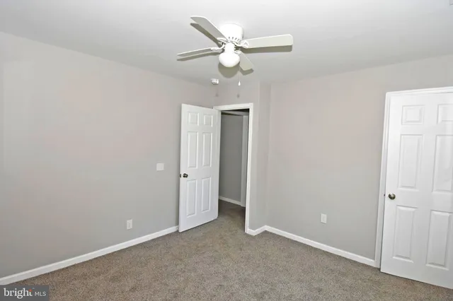 an empty room with a ceiling fan and a window