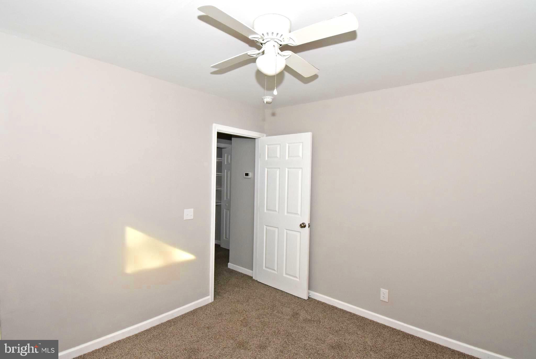 4078 Jacksonville Road Crisfield, MD 21817 - Photo 29 of 43 an empty room with a ceiling fan and a window