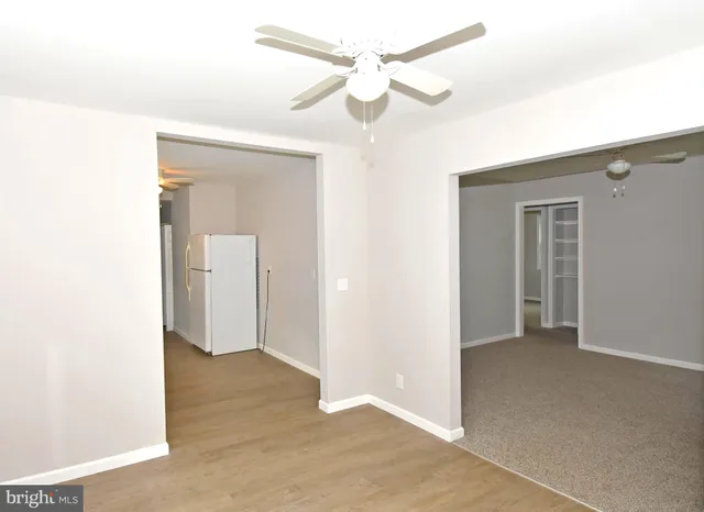 a view of a room with a ceiling fan and entryway
