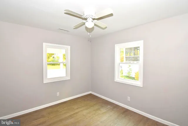 an empty room with a window and a ceiling fan